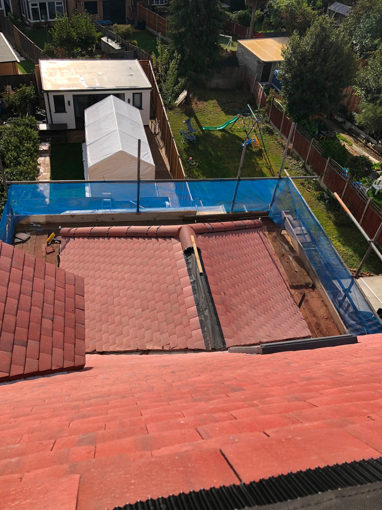 New red roof tiles being installed